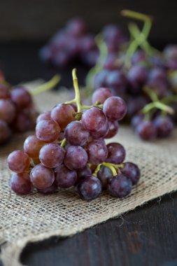 Ahşap masa üzerinde sepet üzüm demet