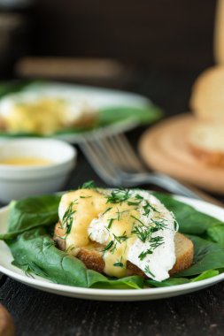 Tahta masada ıspanaklı ekmek üzerinde haşlanmış yumurta.