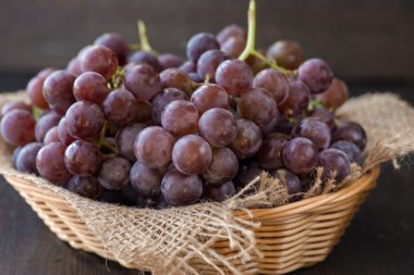 Ahşap masa üzerinde sepet üzüm demet 