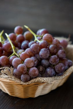 Ahşap masa üzerinde sepet üzüm demet 