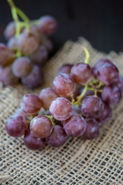 Ahşap masa üzerinde sepet üzüm demet 