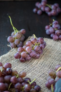 Ahşap masa üzerinde sepet üzüm demet 