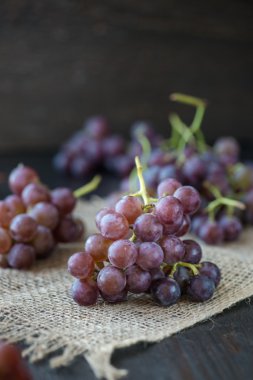 Ahşap masa üzerinde sepet üzüm demet 