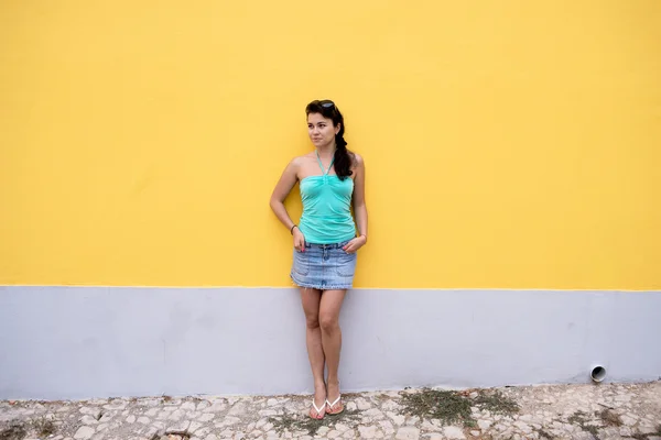 Bella giovane donna in piedi vicino al muro — Foto Stock