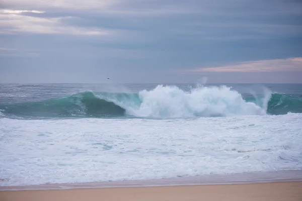 Ola estrellándose en una costa en Nazare, Portugal . — Foto de Stock