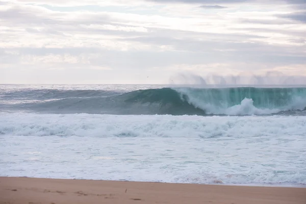 Golven storten neer op een kust in Nazare, Portugal. — Stockfoto