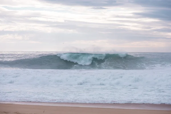 Ola estrellándose en una costa en Nazare, Portugal . — Foto de Stock