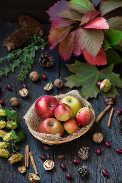 Pommes fraîches avec feuilles d'automne sur table en bois — Photo