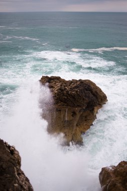 Nazare 'de bir kıyıya dalga çarpıyor.