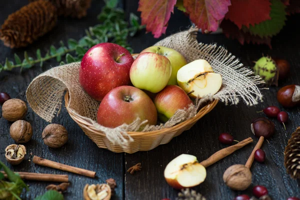 Fresh apples with autumn leaves on wooden table — Stock Photo, Image