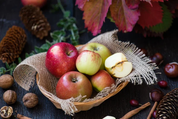 Fresh apples with autumn leaves on wooden table — Stock Photo, Image