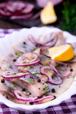 Ringa balığı salatası soğan ve otlar ve limon ile