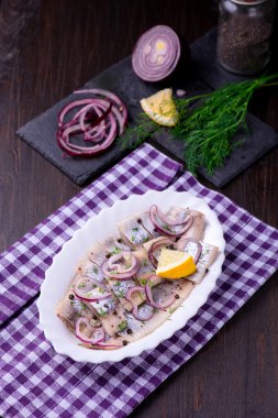 Ringa balığı salatası soğan ve otlar ve limon ile