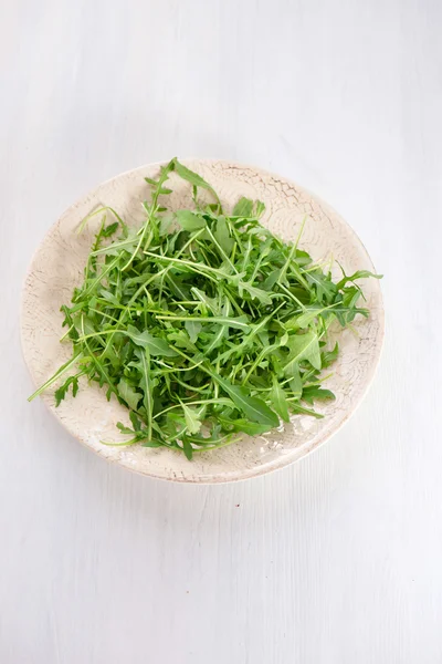 Färsk rucola lämnar i plattan — Stockfoto