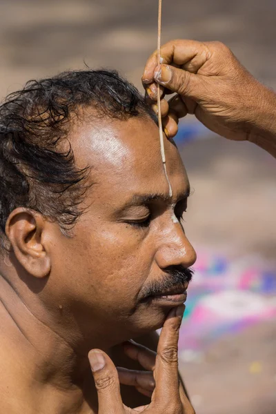 White line is painted on man 's forehead . — стоковое фото