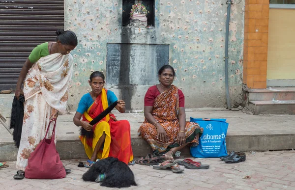 Três mulheres vendem cabelo humano na rua . — Fotografia de Stock