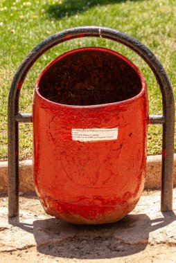 Vina Del Mar, Şili - 8 Aralık 2008: Küçük kırmızı metal belediye çöp tenekesi yeşil çimlere karşı.