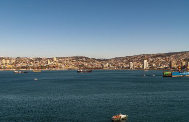 Valparaiso, Şili - 8 Aralık 2008: Mavi gökyüzü altında ufuktaki tepelerde kentsel manzara ile koyu gök mavisi üzerine geniş görüş. Limana yakın demirlemiş bazı gemiler var..
