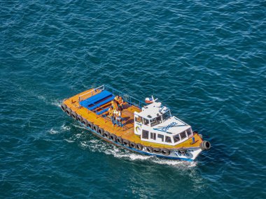 Valparaiso, Şili - 8 Aralık 2008: Mavi okyanus suyunda limandaki insanlarla birlikte pilot botun kapatılması.