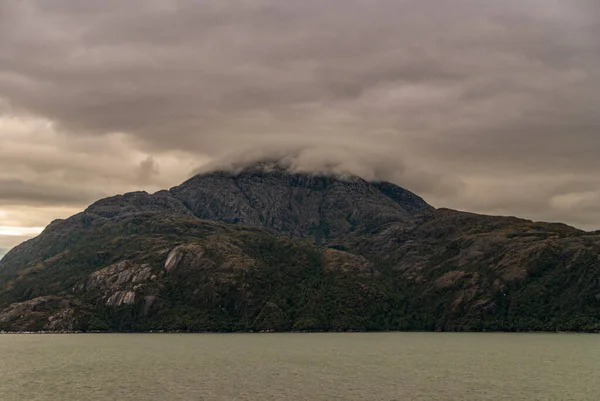 Sarmiento Channel 2008年12月11日 Amalia Glacier Fjord 灰色の雲が降下し 暗い岩の山の頂上を包み込みます 水を前に — ストック写真