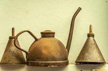 Riesco Adası, Şili - 12 Aralık 2008: Posada Estancia Rio Verde çalışma çiftliği. Sarı duvara karşı eski kahverengi metal yağ kutuları koleksiyonu..