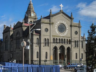 Punta Arenas, Şili - 12 Aralık 2008: Mavi gökyüzünün altında Maria Auxiliadora 'yı şişiren gri çimento kilise. Sokakta arabalar ve önünde mavi çitler..
