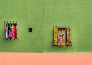 Buenos Aires, Arjantin 19 Aralık 2008, La Boca Mahallesi. 2 dekore edilmiş sarı ve kırmızı boyalı pencereler yeşil duvarda. Çamaşır sergileniyor.