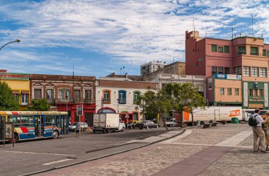 Buenos Aires, Arjantin 19 Aralık 2008, La Boca Mahallesi. Av. Don Pedro de Mendoza ve Matanza Nehri 'nin çevresindeki ikonik evleri. Arabalı sokak sahnesi ve mavi bulutların altındaki insanlar..
