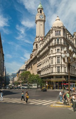 Buenos Aires, Arjantin... 19 Aralık 2008 'de mavi bulutların altındaki şehir meclisi binasının tepesindeki bej taştan saat kulesi. Trafik ve insanların olduğu sokak sahnesi.