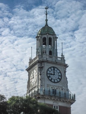 Buenos Aires, Arjantin - 19 Aralık 2008 İngiliz deniz saat kulesinin üst bölümü yeşil yapraklı mavi bulutlu manzaraya karşı. 