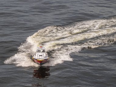 Rio de Janeiro, Brezilya - 22 Aralık 2008: Karanlık okyanus sularında sörf yapan kırmızı-beyaz pilot teknesinin yakınlaştırılması.