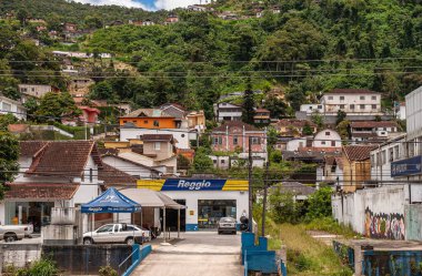 Petropolis, Brezilya - 23 Aralık 2008: Reggio lastikleri ve araba tamir atölyesi, aşağı sokaktaki işçi sınıfı mahallesinde yeşil orman tepesi inşa edilmiş evlerle kuruldu.