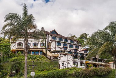 Petropolis, Brezilya - 23 Aralık 2008: Kırmızı çatılı büyük malikane, yeşil dağ yamacına gizlenmiş beyaz duvarlı, mavi yamalı beyaz bulutların altında.