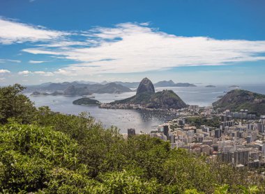 Rio de Janeiro, Brezilya - 24 Aralık 2008: Sugarloaf Dağı üzerinde geniş hava manzarası ve Praia da Urca ile körfeze giriş ve Botafogo mahalleleri. Önde yüksek binalar ve yeşil yapraklar var..