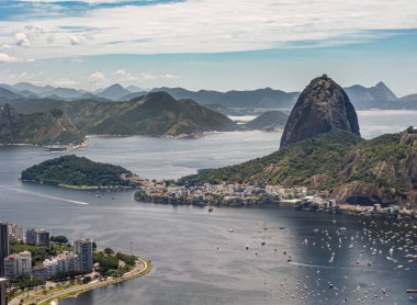 Rio de Janeiro, Brezilya - 24 Aralık 2008: Sugarloaf Dağı 'nın havadan görünüşü ve Praia da Urca Mahallesi ile körfezin girişi ve onun yat limanı gök mavisi bulutları altında. Ufukta dağlar.