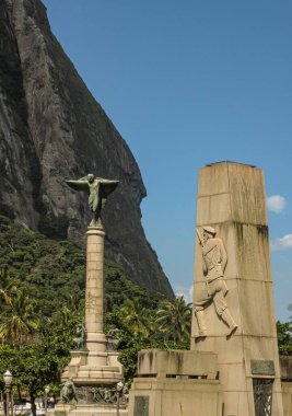 Rio de Janeiro Brezilya - 24 Aralık 2008: Pao de Acucar topraklarındaki savaş anıtları Sugarloaf dağının altında mavi gökyüzünün altında son buluyor. Altta yeşil yapraklar.