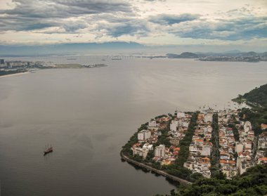 Rio de Janeiro, Brezilya - 25 Aralık 2008: Noel günü. Da Urca ve Do Forte plajları arasında sıkışan küçük bir mahalle. Gök mavisi bulutların altında koyu körfez suyuyla çevrili..