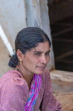 Kadenahalli, Karnataka, Hindistan - 3 Kasım 2013: Kulak mücevherleri ve pembe elbiseli genç çiftlik kadınının portresi.