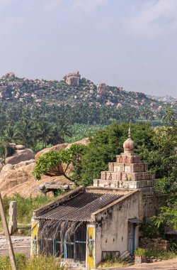 Krishnapura, Karnataka, Hindistan - 4 Kasım 2013: Sasivekaly Ganesha yakınlarındaki ağaçlar veya mavi gökyüzünün altındaki Hardal Tohumu heykeli tarafından gizlenmiş piramit tapınağı. Arkaplan olarak Rocky Hill.