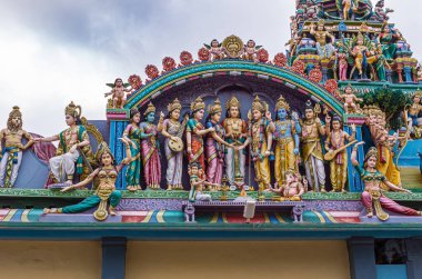 Kadirampura, Karnataka, Hindistan - 4 Kasım 2013: Sri Murugan Tapınağı. Mavi bulutların altında Murugan 'ın düğününü temsil eden renkli heykellerin yakın çekimi..