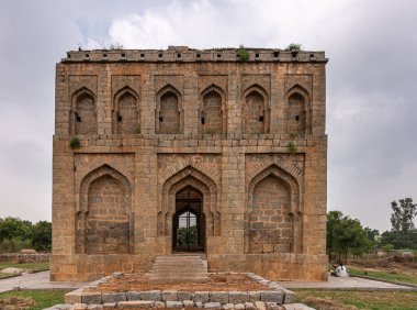 Kadirampura, Karnataka, Hindistan - 5 Kasım 2013: Dargah ve mezarlar. Açık mavi sabah gökyüzünün altındaki İslami tapınağa cephe manzarası. Yeşil otlar, çimenler ve biraz yeşillik..