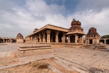 Hampi, Karnataka, Hindistan - 5 Kasım 2013: Sri Krishna tapınağı yıkıldı. Mavi bulutların altında kahverengi taş binaların olduğu orta avlu manzarası.
