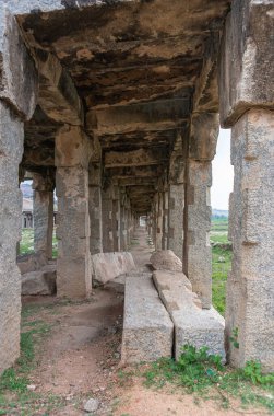 Hampi, Karnataka, Hindistan - 5 Kasım 2013: Sri Krishna tankı harabe halinde. Gri bir taştan bakmak yıkıcı bir galerinin başından sonuna bir tüneldeki gibi. Kalıplı tavan ve biraz çimen..