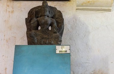 Hampi, Karnataka, Hindistan - 5 Kasım 2013: Zanana Enclosure. Siyah taş Tripur Bhairavi heykeli beyaz duvara karşı mavi kaidede.