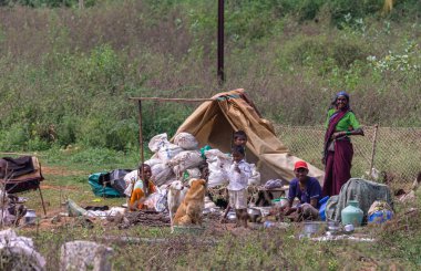 Hampi, Karnataka, Hindistan - 5 Kasım 2013: Ancient Aqueduct. Çocukları ve köpekleri olan, çadırları ve eşyaları çantalarında olan mutlu evsiz bir aile..