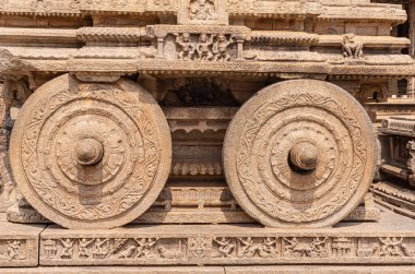 Hampi, Karnataka, Hindistan - 5 Kasım 2013: Vijaya Vitthala Tapınağı. Kompleksin merkezindeki bej taştan savaş arabası heykelinin oyulmuş tekerleklerinin yakınlaştırılması.