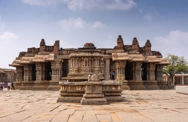 Hampi, Karnataka, Hindistan - 5 Kasım 2013: Vijaya Vitthala Tapınağı. Mandapam salonu olan Brownstone ana mabedi mavi bulutların altında merkez avludan görüldü. Giysi renk katar.