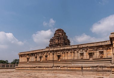Hampi, Karnataka, Hindistan - 5 Kasım 2013: Vijaya Vitthala Tapınağı. Batı harabe gopuram mavi bulutların altında kahverengi taş tarafında dikiliyor..