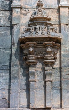 Lakkundi, Karnataka, Hindistan - 6 Kasım 2013: Brahma Jinalaya tapınağı. Gri ve kahverengi taş oyuk şekilli heykel dış duvarın dekorasyonu için.