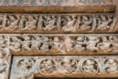 Lakkundi, Karnataka, Hindistan - 6 Kasım 2013: Kasivisvesvara Tapınağı. Fransa 'nın yan kapı girişindeki kahverengi taş heykellerinin ayrıntıları. Sıra sıra insan figürleri.